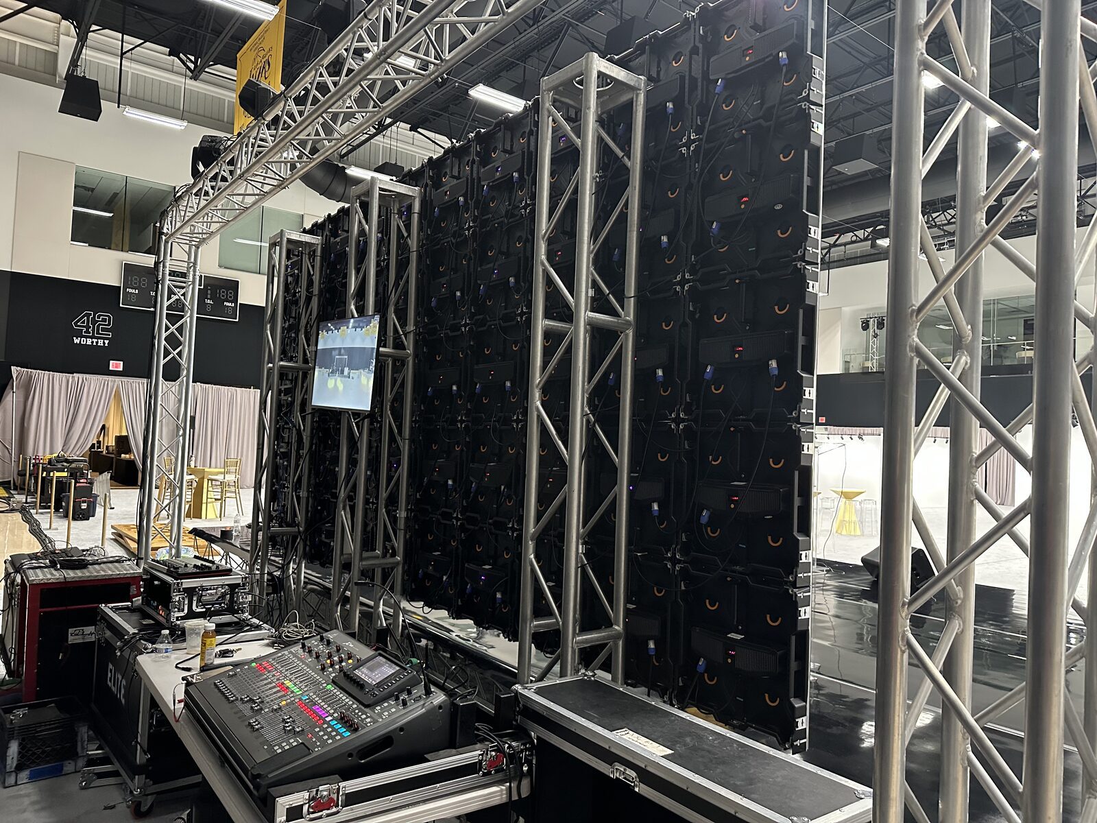 Behind the video wall · panel cabling, confidence monitor and the front-of-house audio console.